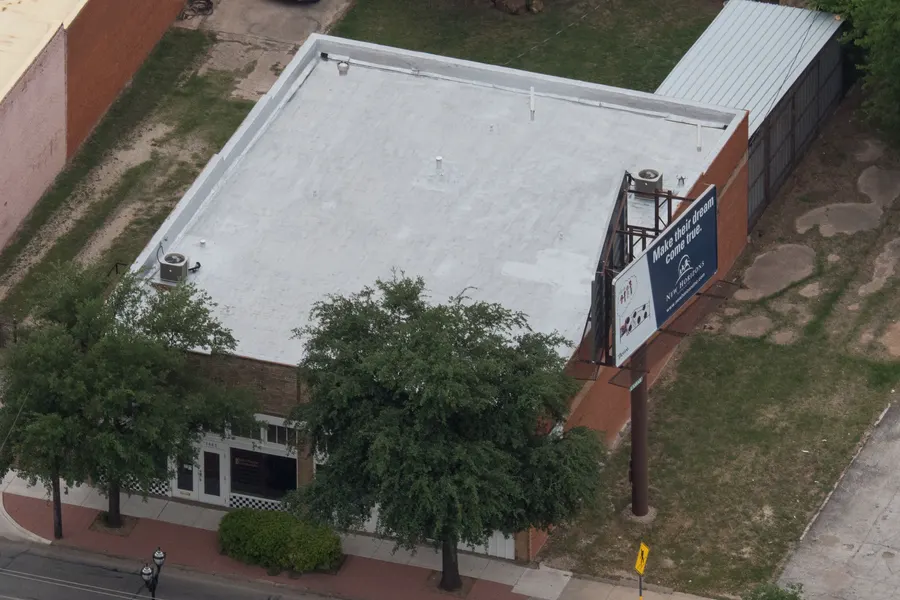 White flat commercial roof on a brick building