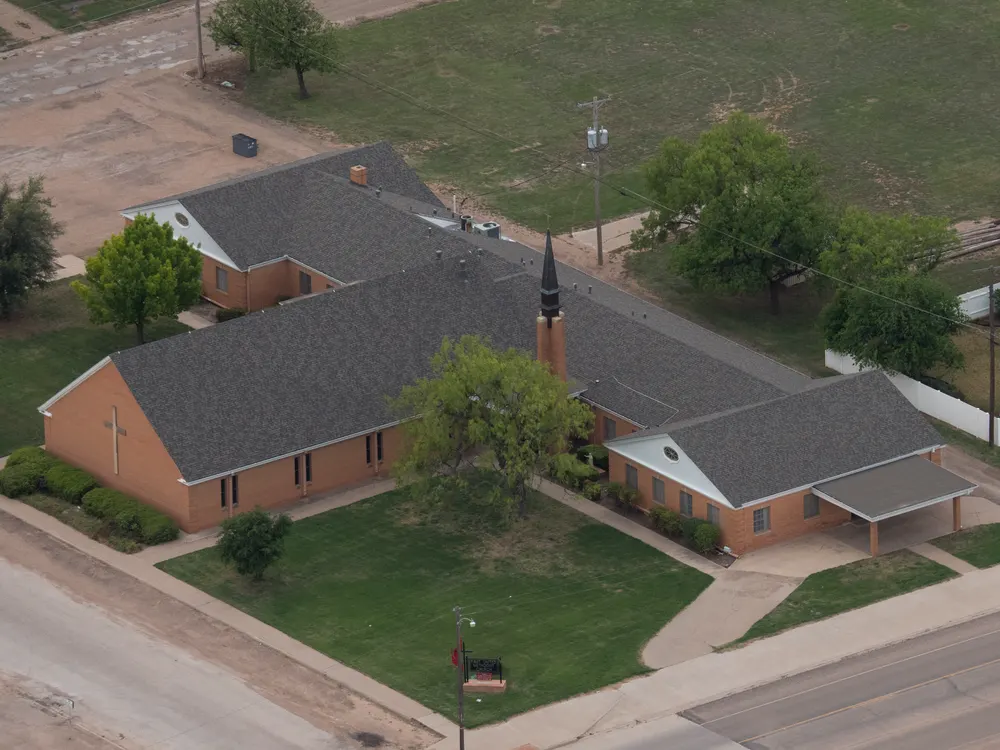 Church with a gray roof and a small steeple, seen from above